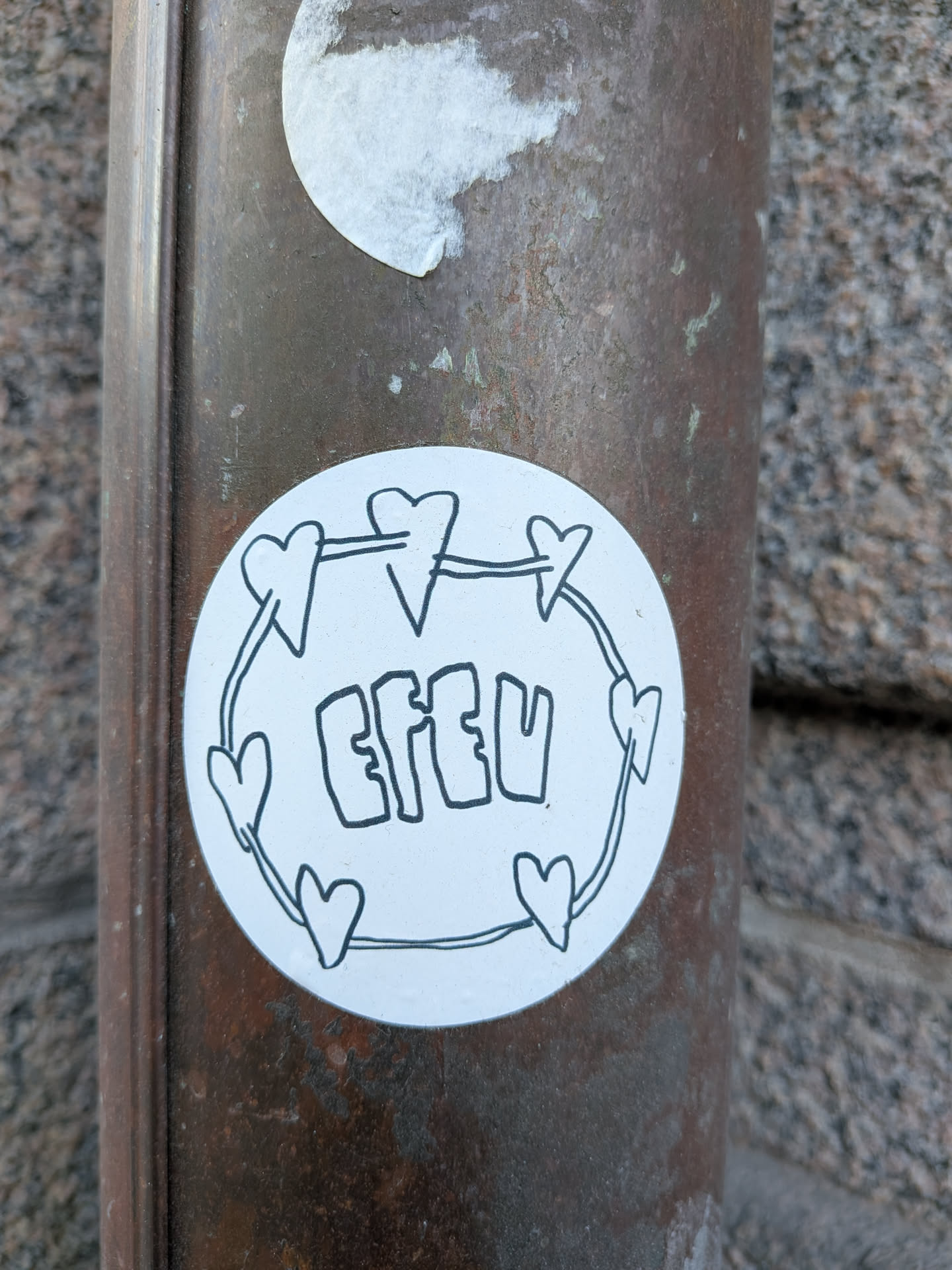 The sticker is circular with a white background, featuring a simple, hand-drawn design in black outline. A thin line connects several small, stylized hearts around the perimeter, forming a circular frame. Inside this frame, the word "EFEU" is written in a bold, bubble-letter style, also in black outline. The overall aesthetic is minimalist and doodle-like.