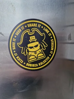 Round sticker featuring a cartoon pirate with a cassette tape on his head. The text around the character says:  Seed it, Share it, Link it, Stream it, Save it, Click it.  The name Dubioza Kolektiv is at the bottom.