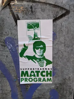 Street sticker A rectangular sticker, predominantly white with bold green graphics and text. It features a stylized, silhouetted figure from the chest up, wearing dark sunglasses and a suit or jacket with a collared shirt and a striped tie or scarf. The tie/scarf has the letters 'HIF' vertically arranged. The figure's left hand (from the viewer's perspective) is raised, holding a smaller, framed image. This smaller image is a green-and-white graphic of a shirtless male athlete in action, with 'MATCHPROGRAM' and '#1' visible. Below the main figure, in large, bold green letters, is the text 'SUPPORTARNAS' followed by 'MATCH PROGRAM', where the 'A' in 'MATCH' is replaced by a white star. The sticker has a clean, graphic design aesthetic and is adhered to a textured, grey wall with visible wear and some blue and black graffiti.