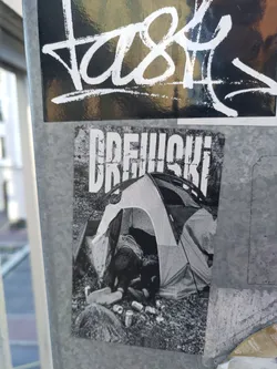 Black and white sticker depicting a person sleeping in a tent surrounded by empty cans. The word DREWSKI is prominently displayed at the top.