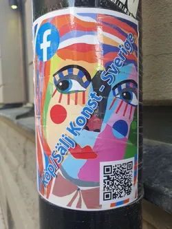 A colorful sticker featuring an abstract face design with text that reads "Köp/Sälj Konst-Sverige" and a Facebook logo.  There is a QR code present on the sticker.