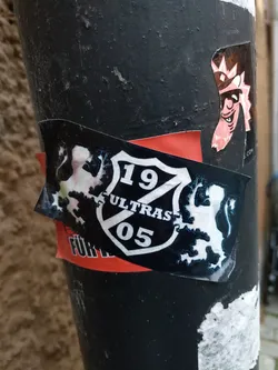 Black and white sticker with a shield and two lions. The text on the shield says 19 ULTRAS 05.