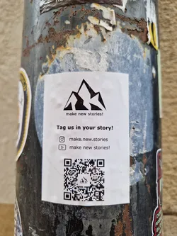 Street sticker A sticker with a mountain logo and a call to action to tag the brand in stories.  It includes Instagram and YouTube handles and a QR code.
