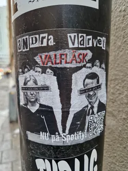 A black and white sticker featuring a collage of faces and text. The text at the top reads "Andra Värvet" and in the middle it says "Valfläsk". At the bottom it says "Nu på Spotify!" and includes a QR code. 
