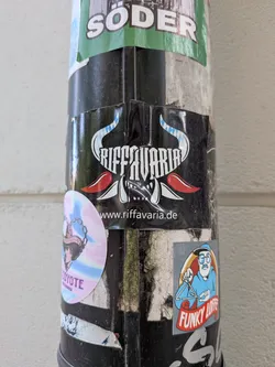 Street sticker Black sticker with stylized white 'RIFF AVARIA' text nestled between blue-and-white checkered horns. Features red accents and the website URL at the bottom.