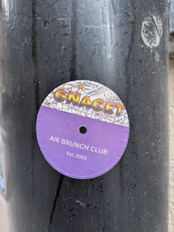 Street sticker A circular sticker styled like a vinyl record. The top section features a map background with 'GNAGET' in gradient text and a star near 'Detroit'. The bottom section is purple with a center hole, reading 'AIK BRUNCH CLUB Est. 2023' in white.