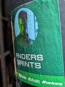 Street sticker A green sticker featuring a portrait of Anders Saints in a circle.  Below the portrait, the name "Anders Saints" is written in a sans-serif font.  At the bottom of the sticker are logos for YouTube, Apple Music, and Bandcamp, indicating social media links to the artist's music.