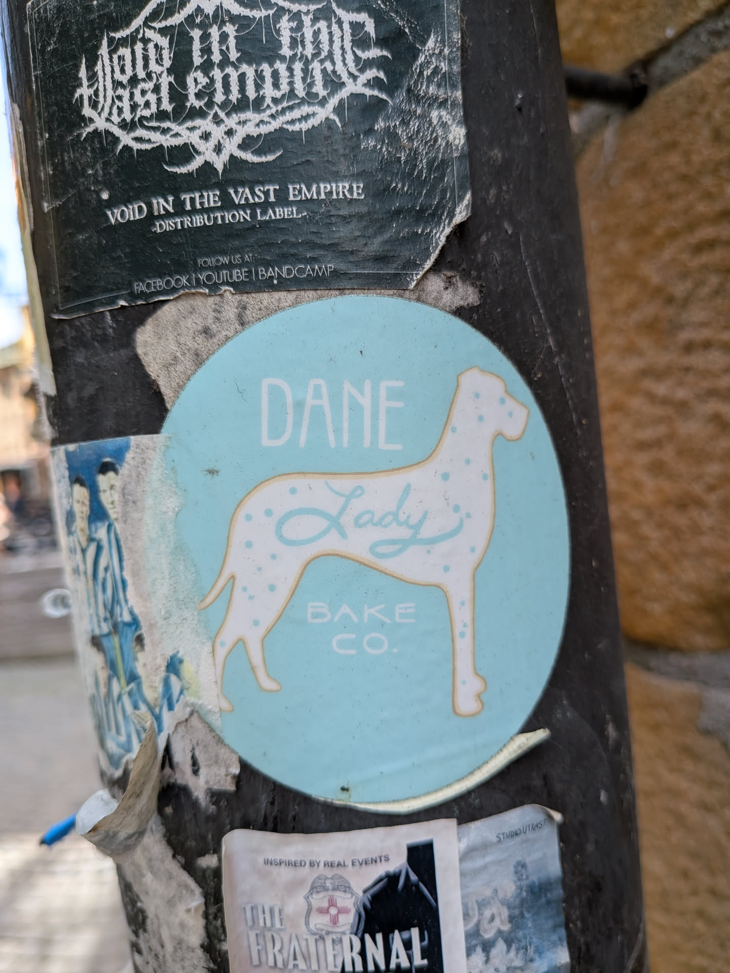 A round light-blue sticker depicting a white Great Dane silhouette with blue spots. Text reads 'DANE' above, 'Lady' in script on the dog, and 'BAKE CO.' below.