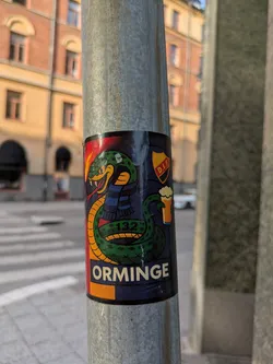 Street sticker The sticker displays a coiled green snake with yellow accents and fangs exposed, set against a dark blue background. The snake is wearing a blue scarf. To the upper right of the snake, there is a shield-shaped logo with red and yellow colors, containing the text 'D.I.F.'. Below the snake's head, the number '132' is visible. To the right of the snake, a glass of beer with foam is depicted. The bottom of the sticker has the word 'ORMINGE' in large, light-colored letters against an orange and dark blue background.