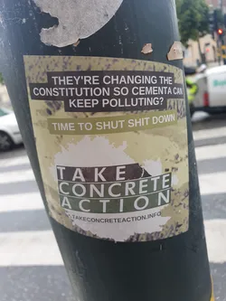 A sticker expressing anger at the changing of the constitution to allow Cementa to keep polluting.  It encourages viewers to take concrete action and provides a website for further information.