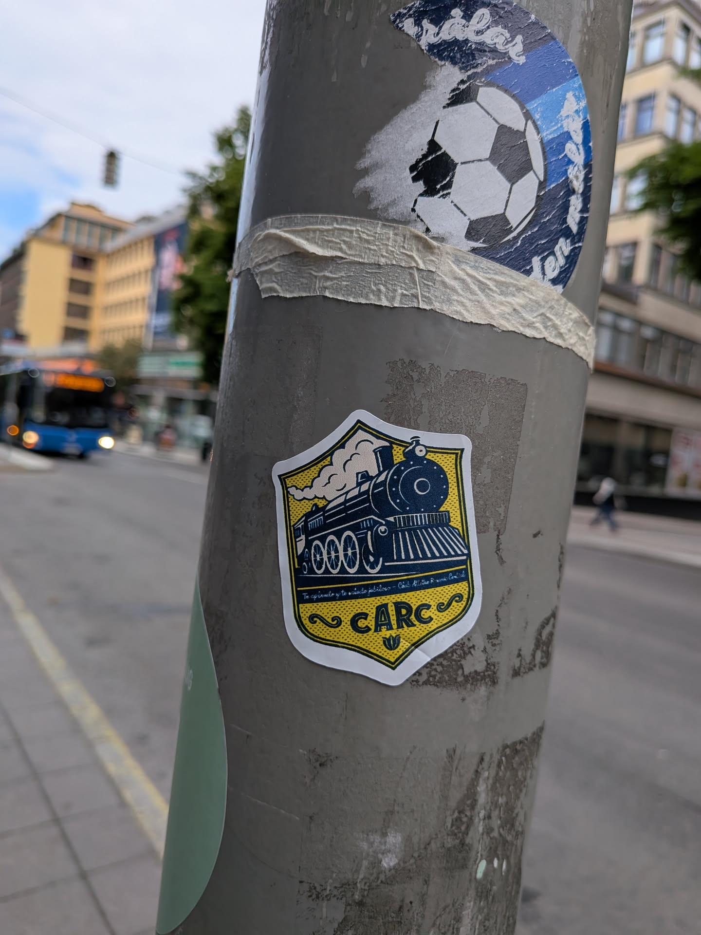 A yellow and blue shield sticker depicting a vintage steam train blowing smoke. The bottom features the acronym 'CARC' and small cursive text on a yellow textured background.