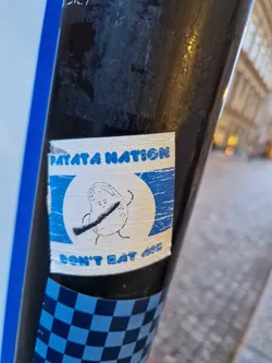 Street sticker A sticker featuring a cartoon potato character wielding a knife, with the text 'Payata Nation' and 'Don't eat me'. The sticker has a distressed, vintage look with a blue and white color scheme.