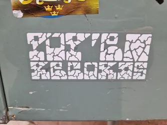 Street sticker White sticker with the text Top10 Records in a unique cracked pattern design. The sticker is affixed to a light gray surface.