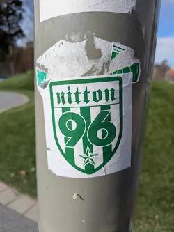 Street sticker The image shows a green and white sticker of what seems to be a sports team named Nitton '96. The sticker has a shield shape, with the name "Nitton" printed at the top in a gothic-style font. Underneath, there's a large "96" and a star.
