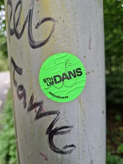 Street sticker A bright green round sticker with black text.  The main text says "STHLM DANS" with a stylized graphic element. At the bottom, a website is visible: sthlmDans.se