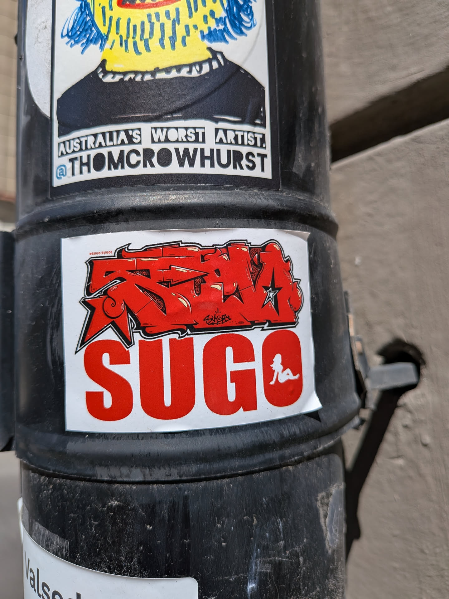 White rectangular sticker featuring a red graffiti-style tag above the word 'SUGO' in bold red block letters. The 'O' contains a white silhouette of a reclining woman.