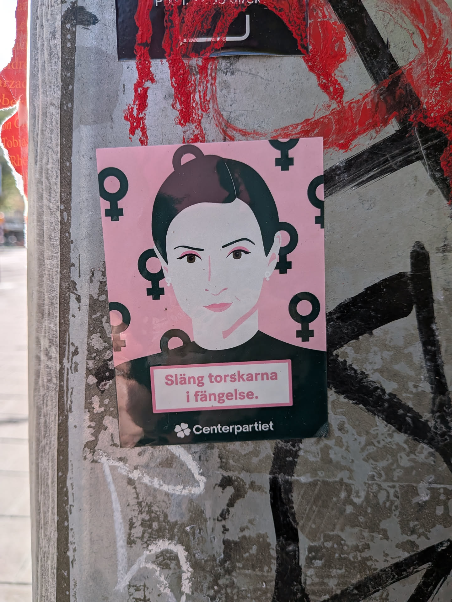 A rectangular sticker depicting a stylized woman's portrait on a pink background patterned with black female symbols. The bottom features Swedish text in a pink box and the Centerpartiet logo on a dark green band.