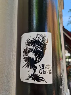 Black and white sticker with a skull graphic and the text "Vegan Flava".
