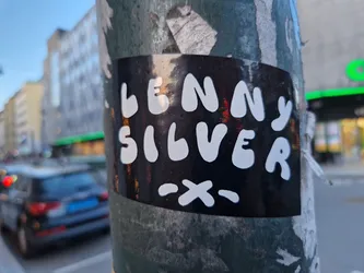 Street sticker A black sticker with the name Lenny Silver written in white, playful lettering.  A small  ~x~ is below the name.