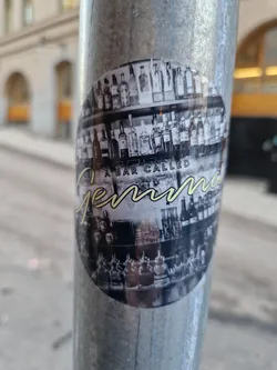 Round sticker depicting a bar's interior with shelves full of liquor bottles. The name of the bar, "Gemma", is written in a stylized script above the image of the bar. The sticker is affixed to a metal pole.