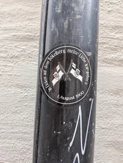 Street sticker A circular black sticker with a white border. It features two crossed flags bearing the Borussia Mönchengladbach logo. White German text arches around the perimeter, commemorating the club's founding date and historic stadium.