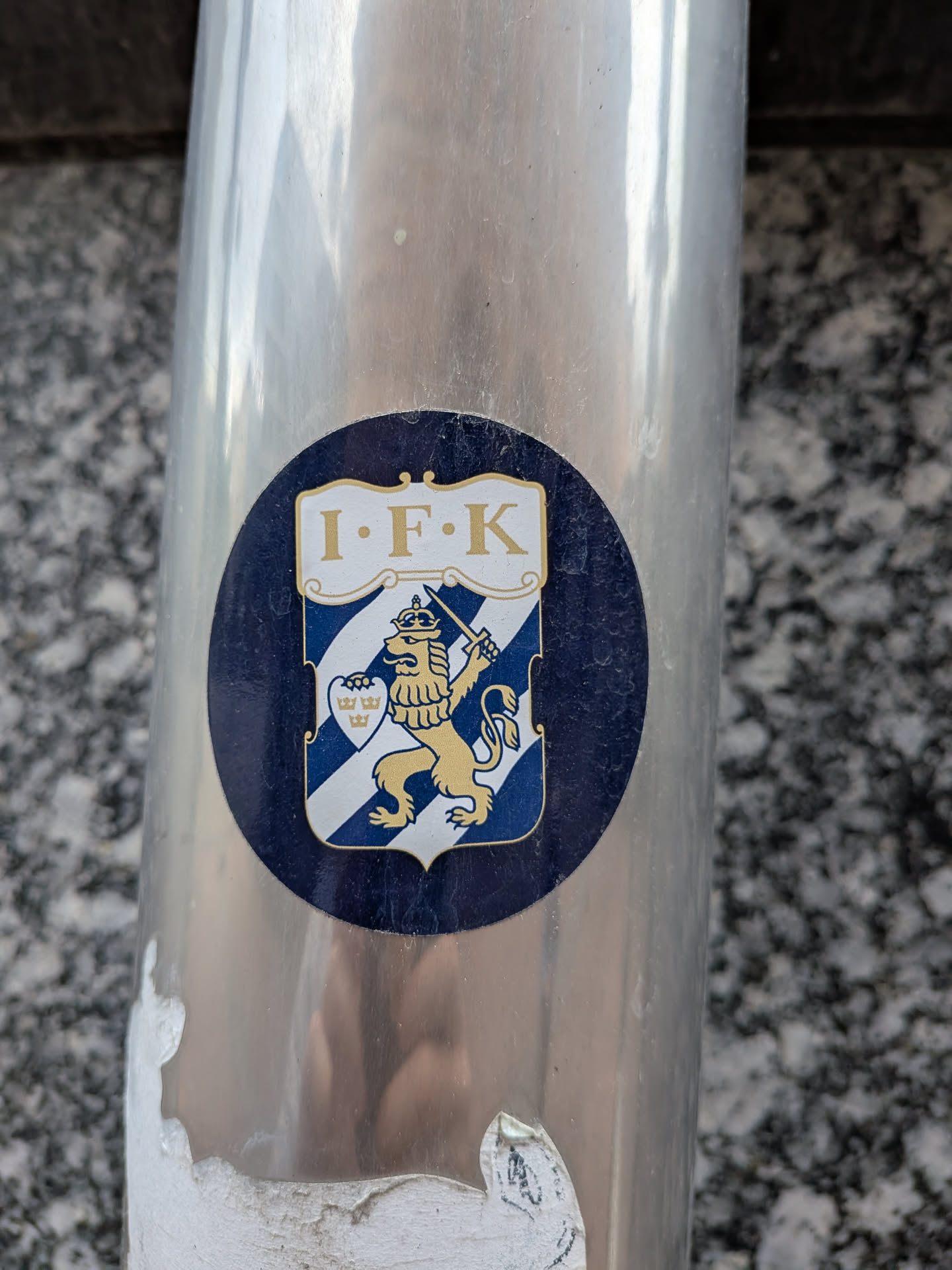 Circular dark blue sticker displaying the IFK Göteborg crest. Features a blue and white striped shield with a golden crowned lion holding a sword, topped by a white banner reading 'I·F·K'.