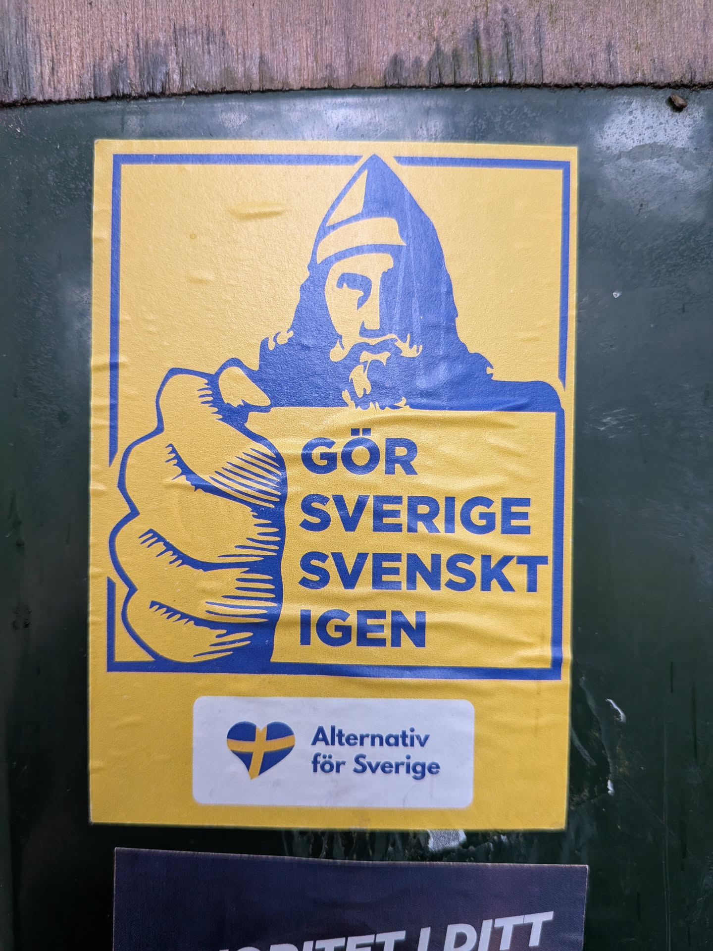 A rectangular yellow sticker with blue graphics. It depicts a stylized Viking pointing forward, mimicking the Uncle Sam pose. The text reads 'GÖR SVERIGE SVENSKT IGEN'. Below, a white section displays the 'Alternativ för Sverige' party logo—a heart with the Swedish flag—and party name.