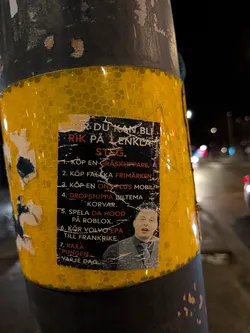 Street sticker A rectangular sticker with a black background and white text, featuring a numbered list of 'easy steps' to become rich. At the bottom right, there's a color photo of a young man with an open mouth, wearing a collared shirt, patterned tie, and a grey vest. The sticker shows signs of wear, with white scuffs and peeling, particularly along the edges and over the black background. It is affixed to a yellow reflective pole with a honeycomb pattern, which is also partially covered in a dark, possibly black, material.