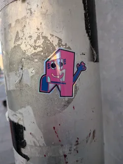 Street sticker The sticker features a stylized, anthropomorphic character with a blocky, geometric design. The main body is predominantly bright pink, with a distinct iridescent or holographic silver section on its left side. It has a simple, smiling face with two black oval eyes and a curved line for a mouth, all outlined in black. On the left side of its head, there are three small blue rectangles. A blue, blocky arm extends from its right side, ending in a five-fingered hand that appears to be waving. Another blue, blocky shape is visible on its lower left side. The entire character is outlined in a thin black border, which is then surrounded by a wider, iridescent/holographic border that shimmers and reflects light.