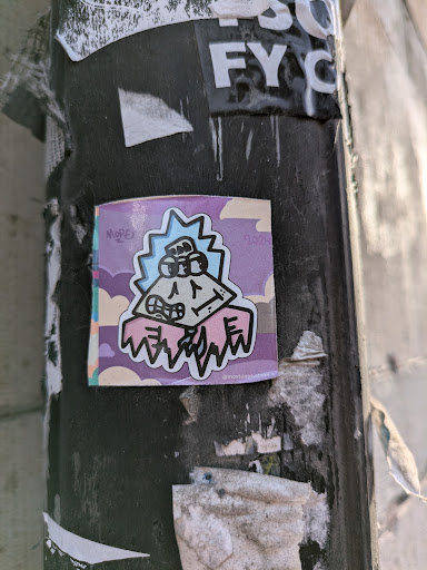 Street sticker A small square sticker featuring a unique cartoon character design. The character has a pyramid-like head with spiky hair and is wearing a pink garment. The background is a pastel purple and pink with light blue clouds. The sticker appears to be hand-drawn and has a slightly rough, textured appearance. There is small text visible in the bottom right and left corners.  The overall style is quirky and playful.