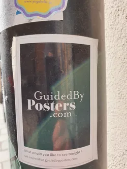 Street sticker A sticker featuring a blurry image and the website GuidedByPosters.com. The text on the sticker asks "What would you like to see tonight?" and directs users to get inspired on the website.