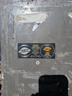 Street sticker A black rectangular sticker featuring white and gold 'Tasty Recordings' mouth logos. The center contains text detailing a music release by Discotron, Jungstedt, and Sticky Decks, listing available streaming platforms and a fanlink URL.