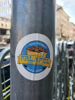 A round sticker featuring an illustration of a falafel pita pocket. The text on the sticker says "Färsk Hemgjord", "FALAFEL STOCKHOLM", and "Sedan 2014".
