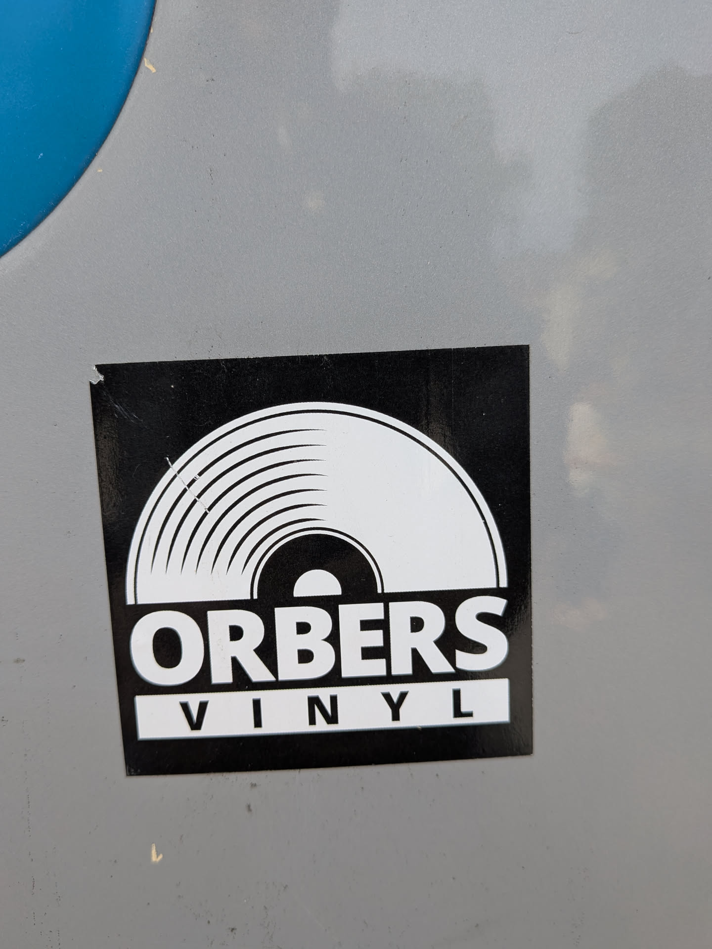 A square black sticker depicting a white stylized vinyl record graphic. Below it, the text 'ORBERS' is printed in bold white, with 'VINYL' in black inside a white rectangular box.