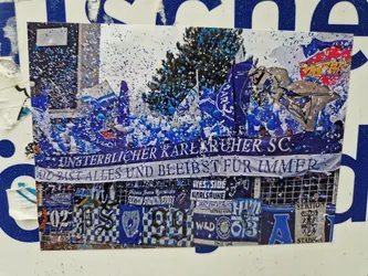Street sticker A sticker depicting a celebratory scene of Karlsruher SC fans amidst blue confetti.  The main banner reads "Unsterblicher Karlsruher SC: Du bist alles und bleibst für immer" (Immortal Karlsruher SC: You are everything and remain forever).  The sticker also features various other fan club banners and designs.