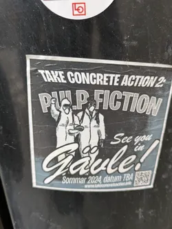 Street sticker A black and white sticker advertising an event called "Take Concrete Action 2: Pulp Fiction" in Gävle, Sweden during Summer 2024.  The sticker features an illustration of two figures in hazmat suits. A QR code is included.