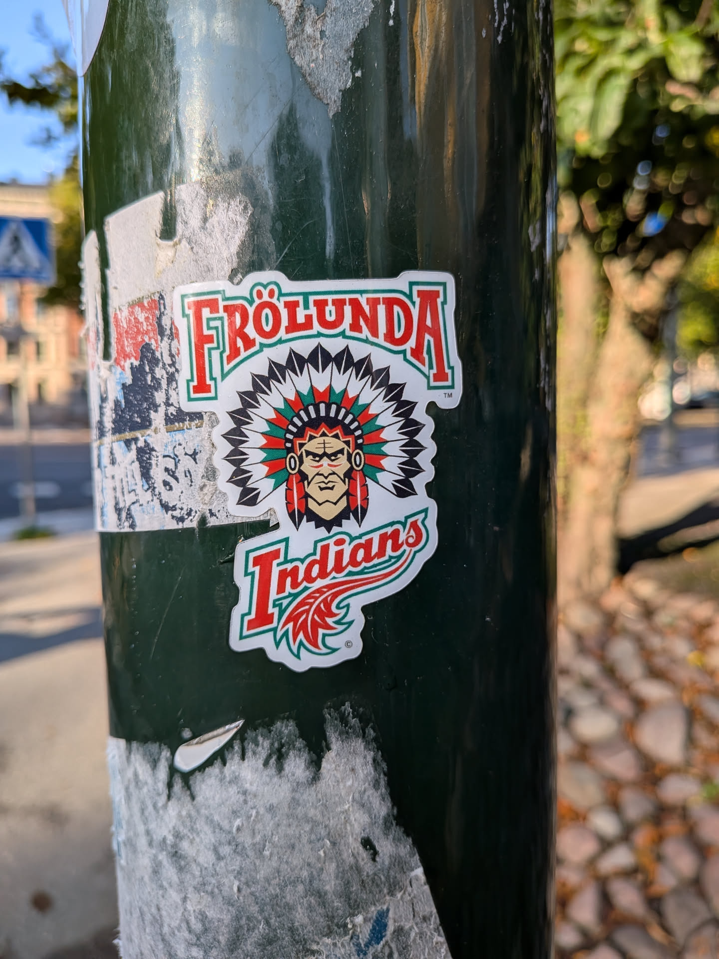 A die-cut sticker of the Frölunda Indians logo, featuring a stylized Native American chief in a red, green, and black feathered headdress. The text 'FRÖLUNDA' arches above, and 'Indians' is written below in red script with green outlines.