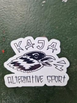 Black and white sticker featuring a stylized crow and the text "KAJA" above and "ALTERNATIVE SPORT" below. The style is reminiscent of punk or alternative graphics.