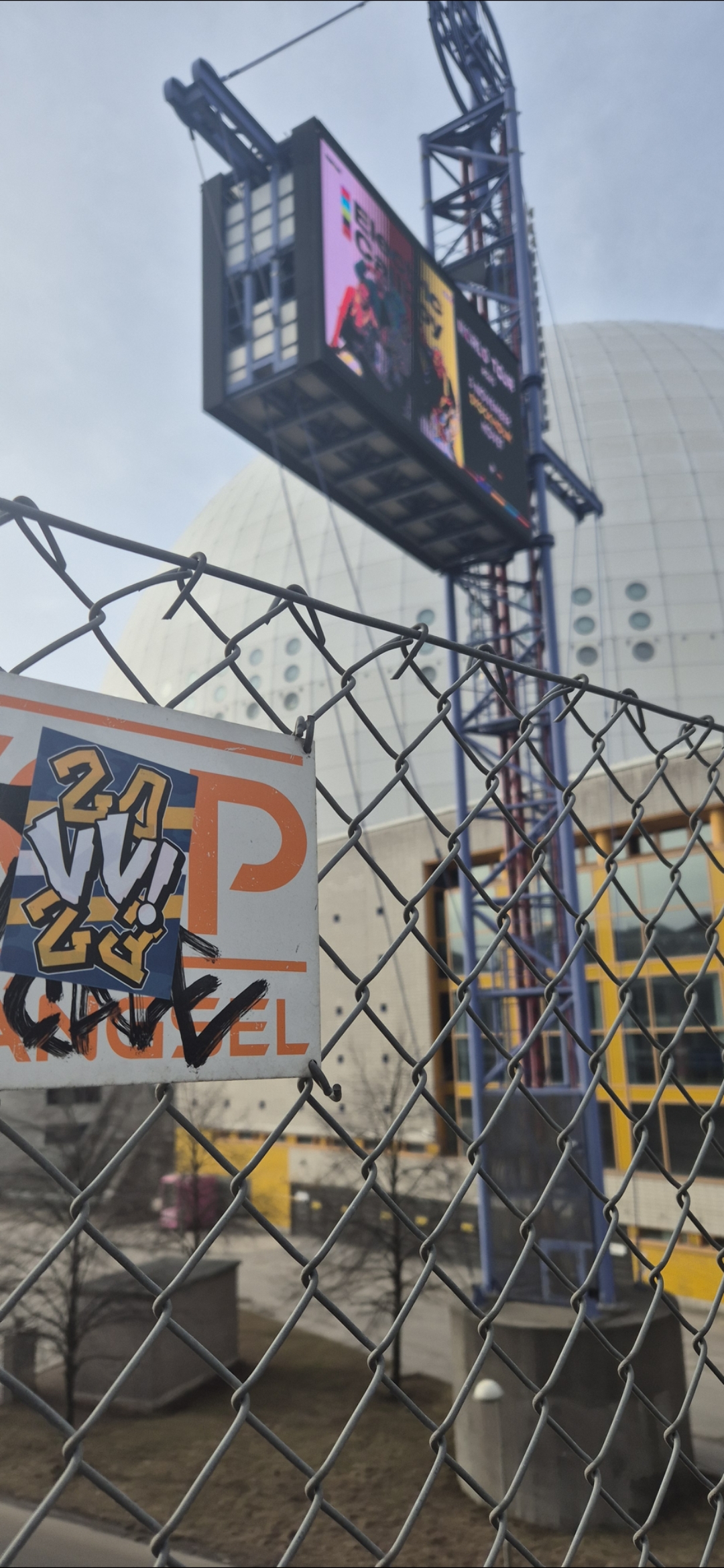 The sticker on the sign features the text "2VI 24" and the word "ANGEL" is below with graffiti marks.