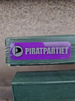 A purple sticker with the logo and name of the Piratpartiet (Pirate Party).