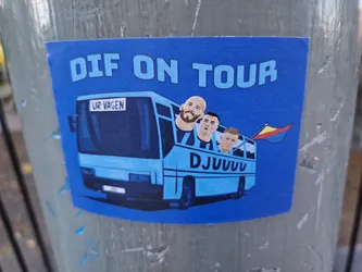 A blue sticker depicting a cartoon bus with three men's faces on it and a small flag. The text 'DIF ON TOUR' is visible at the top, and 'UR VAGEN' is written on the bus. The word 'DJUUUU' is written at the bottom of the bus.