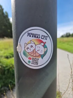 Cute sticker featuring two cartoon cats embracing, with a mango in the background.  The sticker includes a QR code and links to YouTube and Spotify.