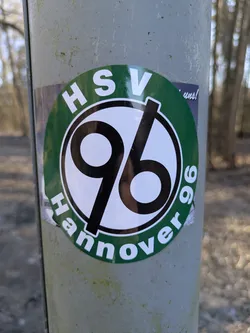 Street sticker The sticker is round and has a white background with a green border. Inside the border, the letters "HSV" are written on the top and the word "Hannover 96" on the bottom. In the center, the number "96" is written in bold black font.