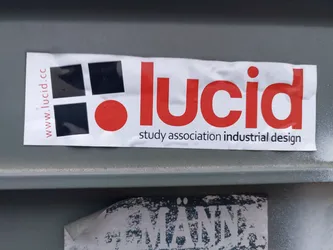 Street sticker A sticker for Lucid, a study association for industrial design.  The sticker features a logo with black squares and a red circle, along with the association's name and website.