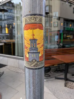 Street sticker An ornate, vertical sticker on a metal pole. It depicts a stone tower with a golden spire under a yellow-orange sky, framed by gold Art Nouveau borders. The bottom features the AIK crest with '1891'.