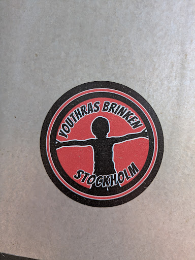 This is a round sticker with a black and red design. The text 'YOUTHRAS BRINKEN' is written on the top part of the circle and 'STOCKHOLM' on the bottom part. In the center is a silhouette of a person with arms outstretched.
