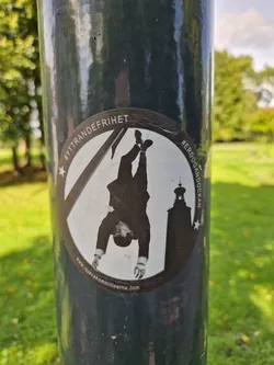 Street sticker A sticker depicting a man hanging upside down next to a tower, with the hashtags #Yttrandefrihet (Freedom of Expression) and #Erdogan.  The sticker also includes a website address.