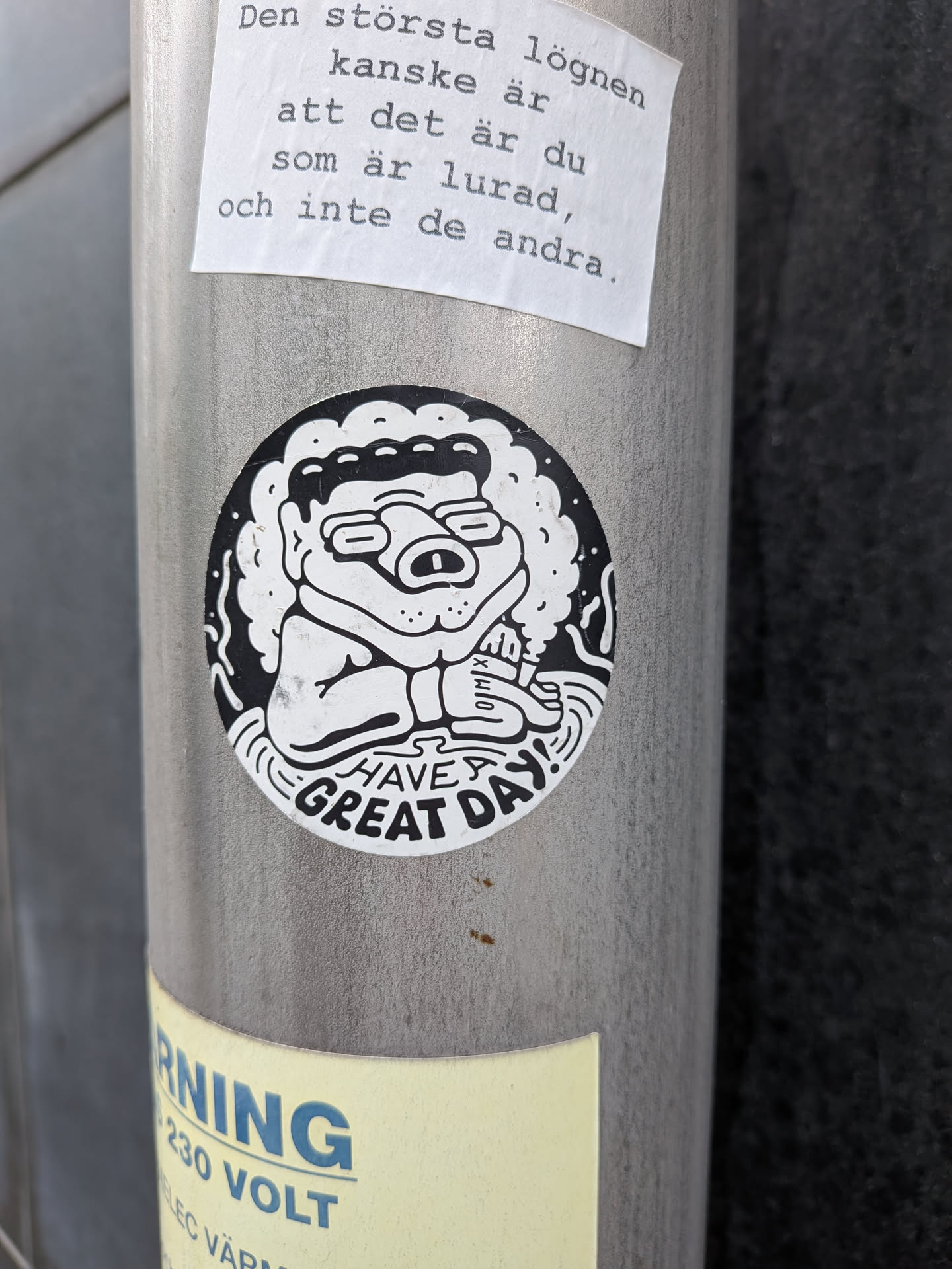 A circular sticker featuring a black and white cartoon character with curly hair and glasses, holding a marker. The bottom edge reads 'HAVE A GREAT DAY!' in stylized uppercase letters.