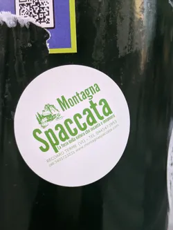 Street sticker A round sticker featuring the logo of Montagna Spaccata, a natural site in Recoaro Terme, Italy. The logo includes a green illustration of mountains and text that translates to "The power of nature that enchants and inspires love." Contact information, including a website and phone number, is also listed.