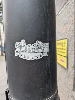 Street sticker A die-cut, black and white sticker featuring a hand-drawn illustration of a shelf. On the shelf are various potted plants, a steaming mug, a pitcher, and a framed picture, each marked with a letter to spell 'SNEAKERS'. Hanging below the shelf is a banner that spells 'HYLLAN'.